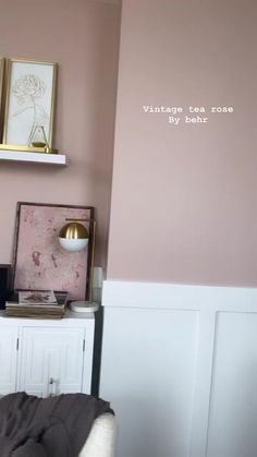 a bedroom with pink walls and gold accents on the wall, along with white furniture