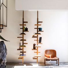 a chair sitting next to a tall wooden shelf