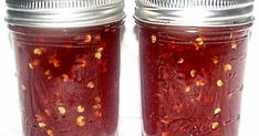 two jars filled with jam sitting on top of a white countertop next to each other