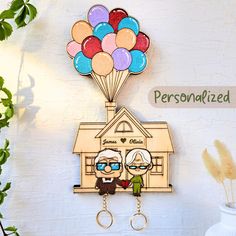 two people are holding balloons in front of a house with the words personalized on it