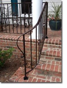 an iron hand rail on the front steps of a house