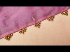 a pink cloth with gold beading on it