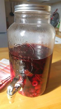 a jar filled with liquid sitting on top of a wooden table