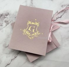 two cards with the letter g on them sitting next to each other, one has a pink ribbon