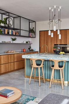 a kitchen with two stools in front of an island and counter top, surrounded by wooden cabinets