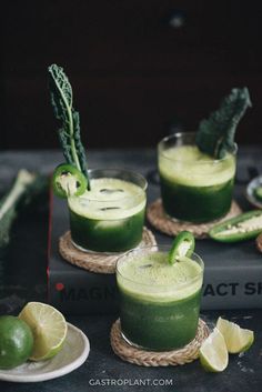 three glasses filled with green liquid and garnished with limes