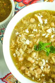 a white bowl filled with green chile chicken soup