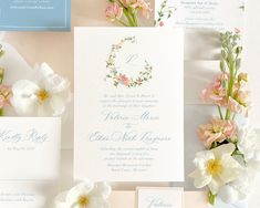 the wedding stationery is laid out with flowers