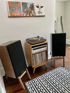 a record player sitting on top of a wooden table next to a rug and chair