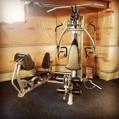 an exercise bike in the corner of a room with some boxes on the wall behind it