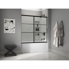 a bath room with a toilet and a walk in shower next to a wall mounted towel rack