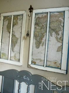 two old windows with maps hanging on the wall