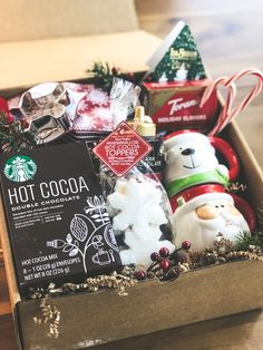 the starbucks holiday gift box is packed with hot cocoa, marshmallows and christmas decorations