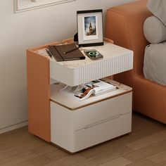 a small white table with an open drawer underneath it and a framed photograph on top