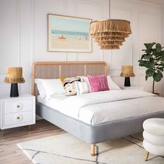 a bedroom with a bed, nightstands and pictures hanging on the wall above it