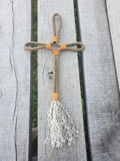 a cross made out of rope on top of a wooden bench