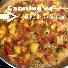 a pot filled with food sitting on top of a stove next to a sign that reads canning peach salsa