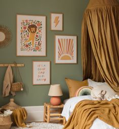 a bedroom with green walls and pictures on the wall above the bed, along with a teddy bear