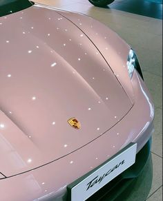 a pink sports car is on display in a showroom