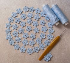 blue crochet flowers are next to a pair of scissors and thread