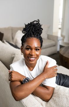 a woman sitting on top of a couch in a living room