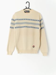 80s vintage Eisbär wool jumper in beige and blue, made in Austria. This jumper features a crew neck and an Eisbär embroidered logo on the bottom left of the jumper. Made in Austria from a heavy weight coarse wool, this jumper is ideal for staying toasty warm in the winter months. Our recommended size: Medium Label says: Medium to large Condition: Very good  Material: 100% pure new wool Measurements in inches: Pit to pit: 20 Shoulders: 18 Front length: 27.5 Back length: 27 Sleeve length: 25.5 Hem Cream Crew Neck Sweater For Winter, Retro Cotton Beige Sweater, Cream Retro Winter Sweater, Retro Beige Cotton Sweater, Vintage Wool Crew Neck Sweater, Vintage Crew Neck Sweater For Winter, Retro Crew Neck Cream Sweater, Retro Cream Crew Neck Sweater, Cream Wool Sweater With Fair Isle Pattern