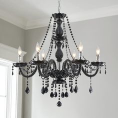 a chandelier hanging from the ceiling in a room with white walls and windows