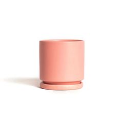 a pink cup sitting on top of a white table