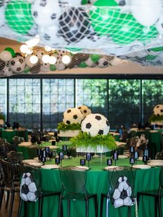 soccer themed tables and chairs are set up for a party with green tablecloths