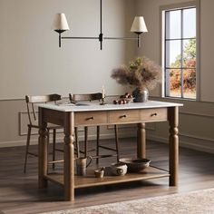 a kitchen island with two pots and pans on it in front of a window