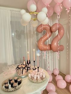 a table topped with pink and white balloons