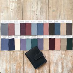 a wallet sitting on top of a wooden table next to color swatches and a card case