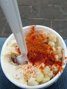 a bowl filled with food on top of a blue cloth next to a white spoon