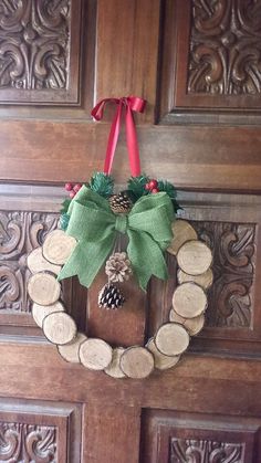 a wooden door with a wreath and pine cones on it