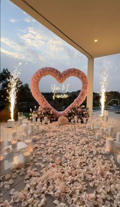 a heart - shaped sign is surrounded by candles and flowers at the end of a wedding ceremony