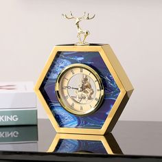 a gold and blue clock sitting on top of a table