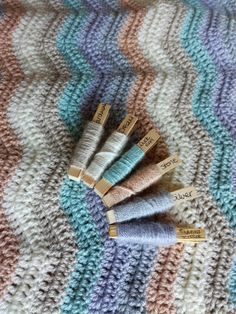 four crocheted needles laying on top of a blanket