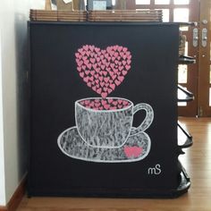 a black box with pink hearts in the shape of a cup and saucer on it