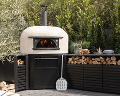 an outdoor pizza oven with wood stacked around it