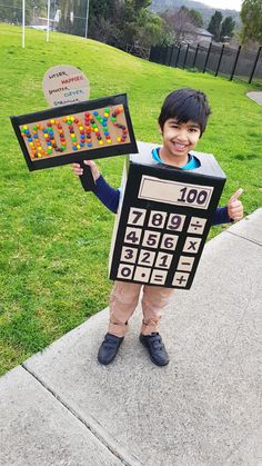 a young boy holding up a board with numbers on it