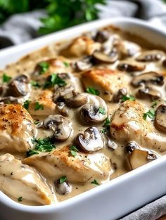 a white casserole dish filled with chicken and mushrooms covered in gravy