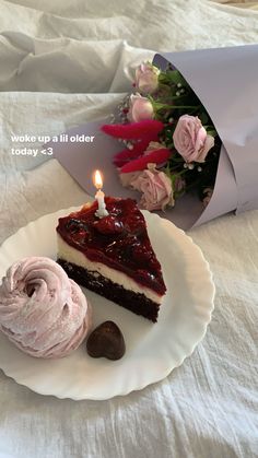 a piece of cake on a plate next to a cupcake with a lit candle