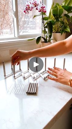 a woman standing at a kitchen counter reaching for utensils in front of her