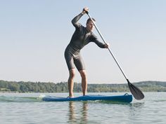 a man paddle boarding in the water on a sunny day