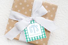 a gift wrapped in brown paper with a white ribbon and tag on the top that says gifts