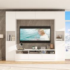 a living room with a large flat screen tv mounted on the wall next to a white entertainment center