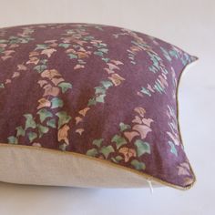 a purple pillow with green leaves on it