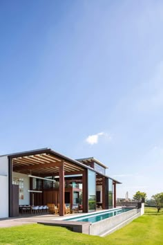 a house with a swimming pool in the middle of it's lawn and covered patio area