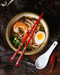 a bowl of noodles with chopsticks and an egg on the side - stock photo - images