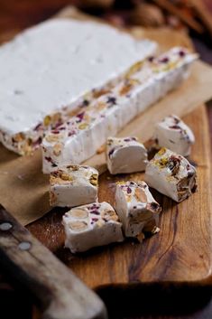 pieces of cake sitting on top of a wooden cutting board